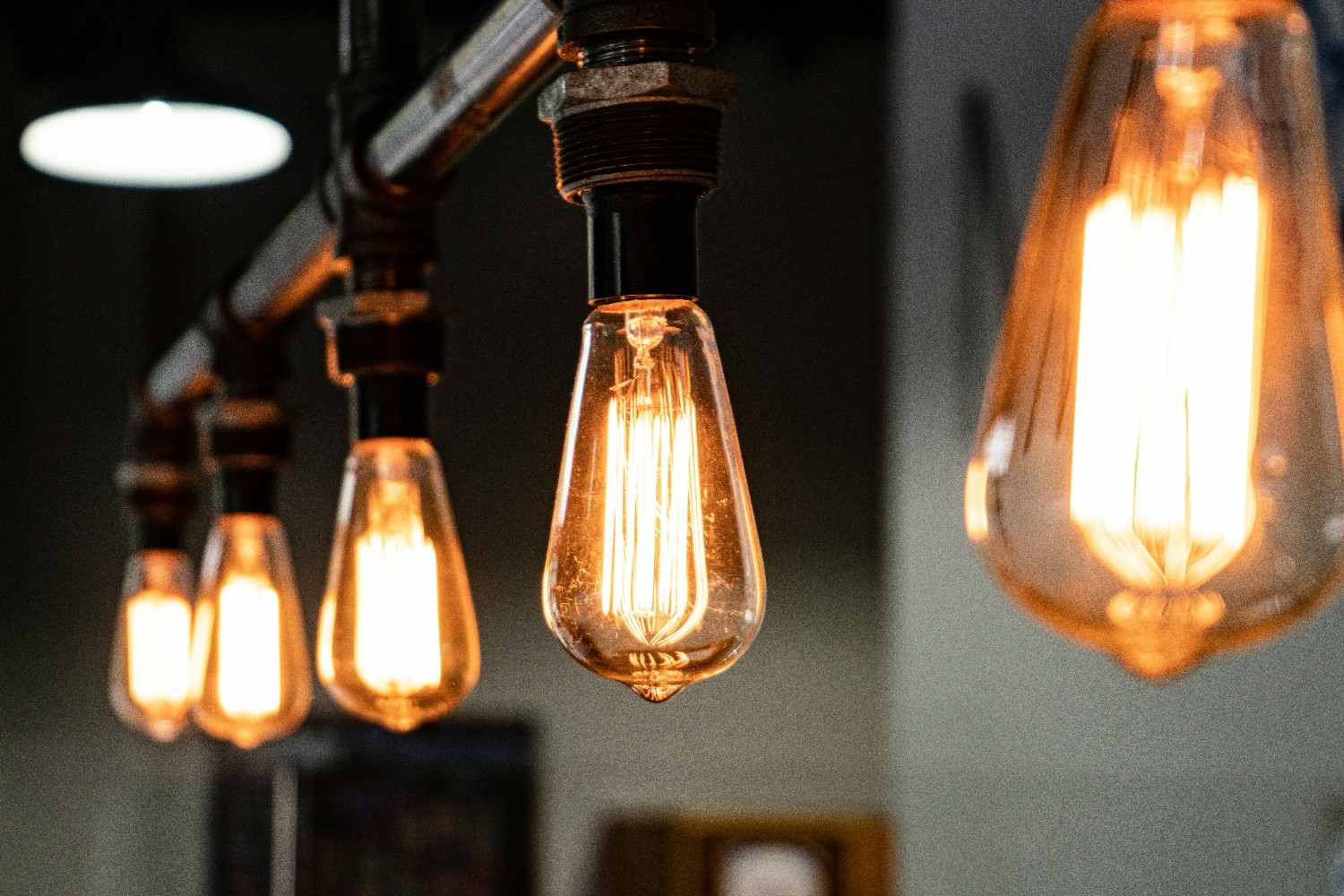 Varias bombillas de filamento encendidas con luz de tono ámbar y casquillos negros.